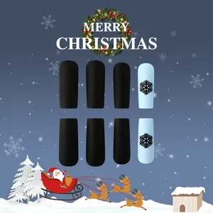 Close-up of matte Christmas press-on nails featuring black snowflakes on light blue finish