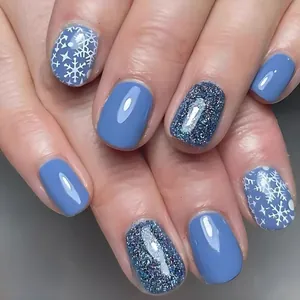 Short square blue press-on nails with white snowflakes and glittering winter design