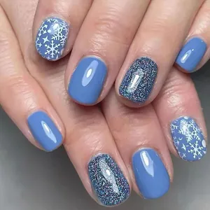 Detailed close-up of glossy short square nails featuring blue snowflakes and silver glitter