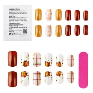 Detail of short square press-on nails with pumpkin, grid patterns and manicure tools