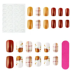 Short square press-on nails set with pumpkin colors, glitter, and plaid pattern details