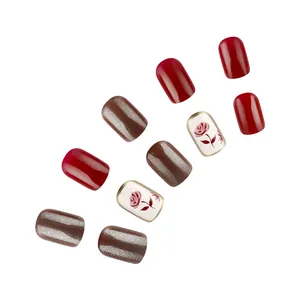 Close-up of short square fake nails with red rose patterns and glitter cat eye finish
