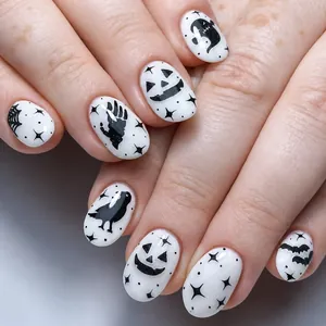 Close-up of Halloween press-on nails with black spider webs ghosts and pumpkin faces