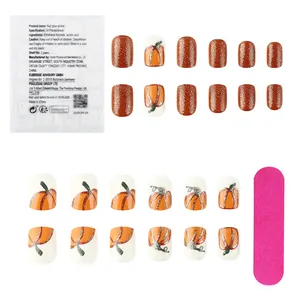 Detail of pumpkin press-on nails set with glitter brown chips and jelly adhesive pads