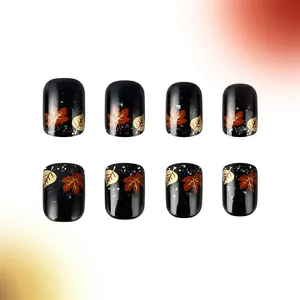 Short glossy black press-on nails featuring autumn maple leaf designs and glitter accents