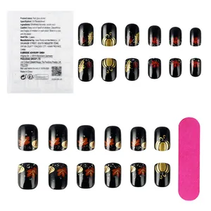 Detail of 24pcs black press-on nails with golden pumpkin and maple leaf patterns