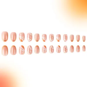 Detail of 24pcs nude and orange press-on nails with daisy patterns and gold glitter
