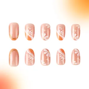 Short French press-on nails with minimalist flower design and glitter orange glossy finish