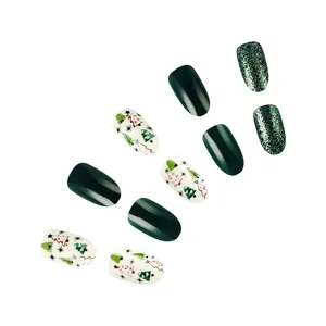 Christmas press-on nails detail featuring green glitter, glossy dark green, and tree art