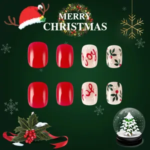 Macro detail of red and white Christmas press-on nails with Joy and Ho! festive patterns
