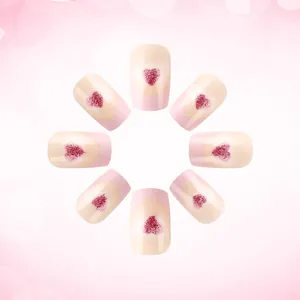 Macro detail of short square pink press-on nails featuring red glitter heart designs