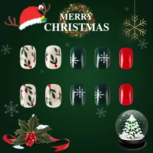 Macro detail of short glossy Christmas press-on nails with snowflakes and holly berry art