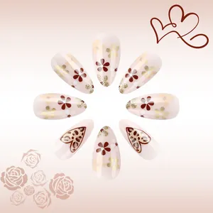 Close-up of almond false nails with leopard hearts, floral patterns and gold glitter