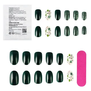 Short glossy Christmas press-on nails set with green glitter and hand-drawn tree designs