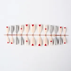 Detail of Christmas short press-on nails set with heart and reindeer horn glitter patterns