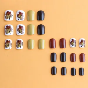 Short square press-on nails with maple leaf patterns and fall colors in 24-piece set
