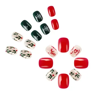 Detail of short square Christmas press-on nails with snowflakes and JOY lettering