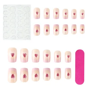 Detailed set of 24 pink press-on nails with red glitter hearts and manicure tools