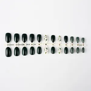 Short oval Christmas nails with deep green glitter and festive tree pattern details