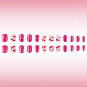 Short square pink glossy press-on nails with heart patterns and glitter accents