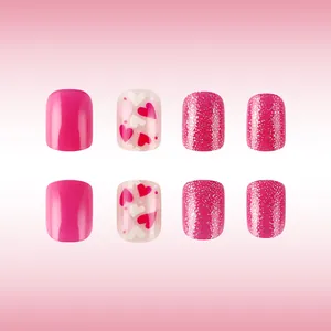 Detail of glossy short square press-on nails with heart patterns and pink glitter