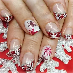 Détail d'ongles carrés avec flocons rouges et blancs et rayures pailletées argentées