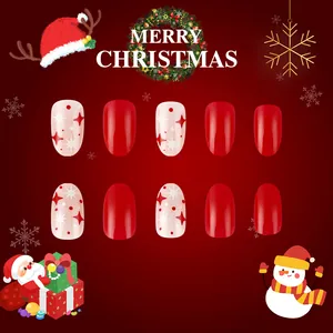 Detail of festive Christmas press-on nails with red stars and white polka dot patterns