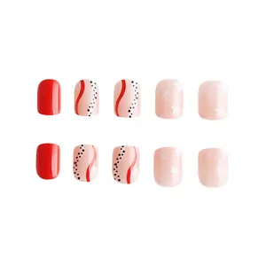 Faux ongles courts carrés avec vernis rouge, pois et motifs d'étoiles blanches