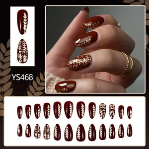Short almond press-on nails with dark red glossy finish and golden wheat ear patterns