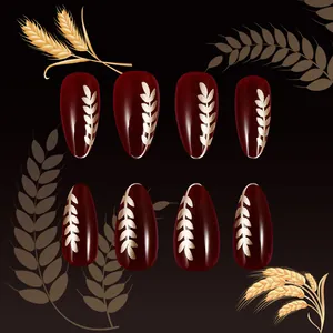 Deep burgundy almond press-on nails with shiny finish and golden wheat ear patterns