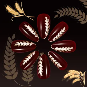 Short almond press-on nails in deep burgundy with golden wheat pattern design