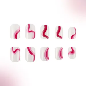 Detailed view of short oval press-on nails with white base and pink wavy line patterns