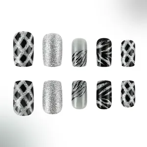 Détails des faux ongles de Noël avec paillettes argentées et motifs à rayures noires