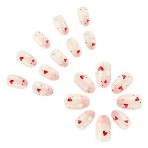 Unghie finte French crema con glitter rosa e decorazioni a forma di cuore rosso