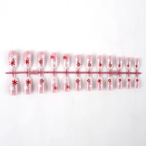 Vista dettagliata di unghie finte natalizie corte rosa con fiocchi di neve e strass