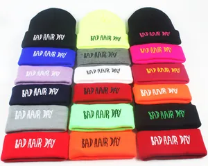Détail de la broderie Bad Hair Day sur une collection de bonnets en maille colorés