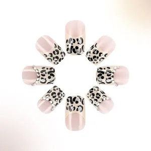 Dettaglio di unghie finte quadrate leopardate con glitter e accenti di strass