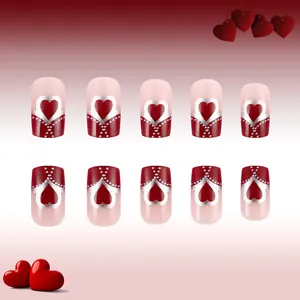 Detail of medium square press-on nails with red heart patterns and silver accents