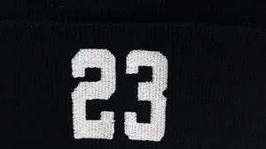 Dettaglio della trama a maglia fine e del numero 23 ricamato in bianco sul berretto