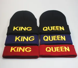Detailansicht der King- und Queen-Stickerei auf Strickmützen in Schwarz, Blau und Weinrot
