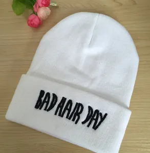 Gros plan sur la broderie noire Bad Hair Day d'un bonnet en tricot blanc élégant