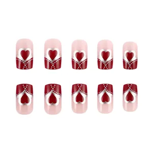 Pink French nails with red tips and silver metallic heart patterns on white background