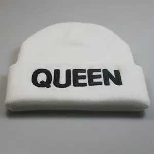 Detail der schwarzen QUEEN-Stickerei auf weißer Strickmütze mit hochwertiger Textur