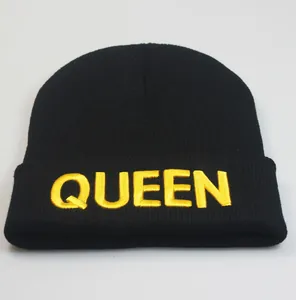 Detailansicht der gelben QUEEN-Stickerei auf einer schwarzen Strickmütze mit Umschlag