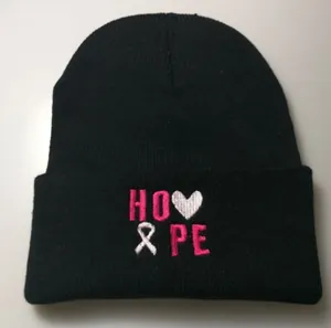 Detail showing colorful Hope embroidery with pink ribbon on a black knitted beanie hat