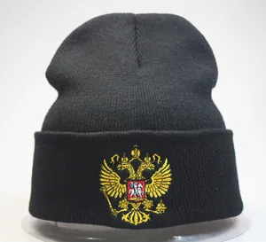 Détail de la broderie dorée des armoiries russes sur un bonnet en tricot noir élégant