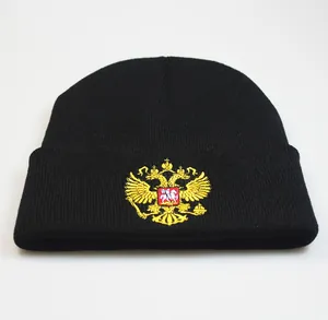 Détail de la broderie des armoiries russes sur le bonnet en tricot noir d'hiver