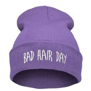 Détail de la broderie blanche BAD HAIR DAY sur un bonnet en tricot violet de style urbain