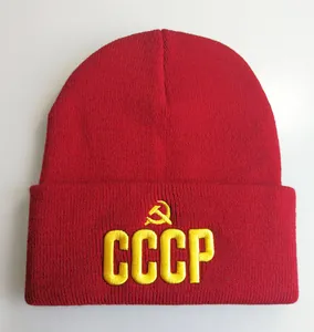 Detail der roten Strickmütze mit gelber CCCP-Stickerei und Hammer-und-Sichel-Symbol