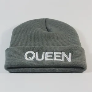 Detailansicht der grauen Strickmütze mit weißer QUEEN-Buchstabenstickerei auf dem Umschlag
